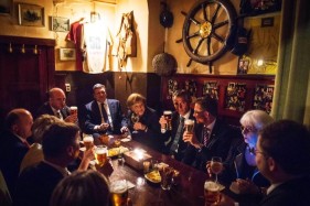Chancellor Merkel and her guests raise their glasses in a traditional pub 